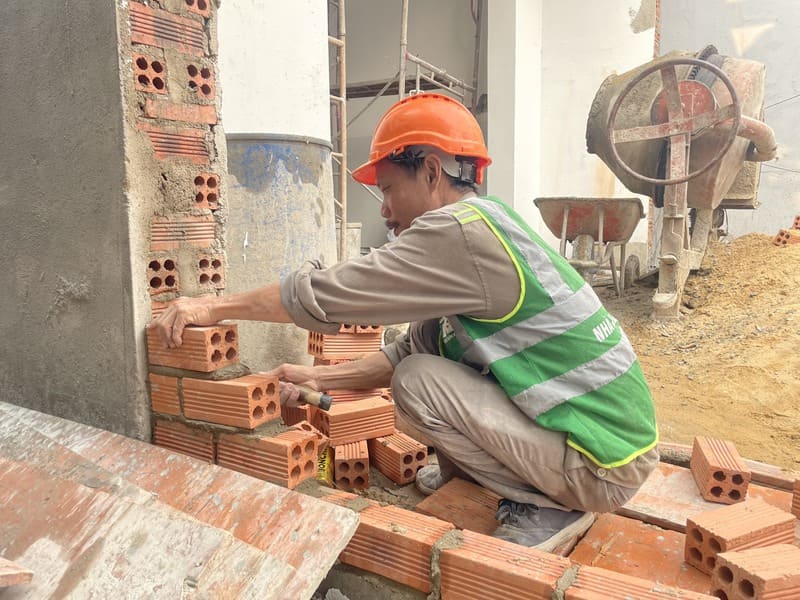 Đội ngũ thợ xây hoàn thiện tường gạch nhà
